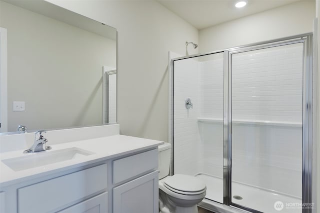 bathroom featuring vanity, a shower stall, toilet, and recessed lighting