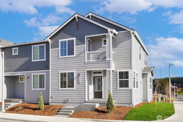 view of front of house with a front lawn and a balcony