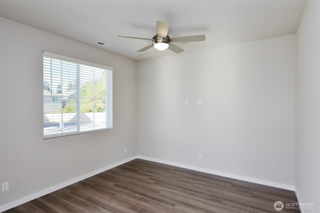 spare room featuring baseboards, dark wood-style flooring, and ceiling fan