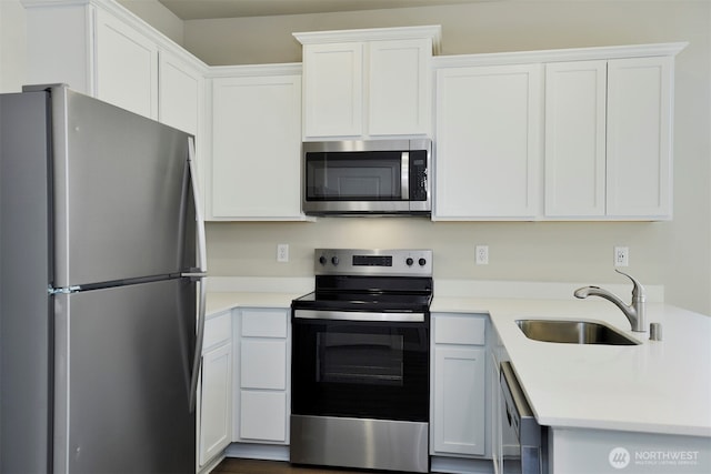 kitchen featuring light countertops, white cabinets, appliances with stainless steel finishes, and a sink