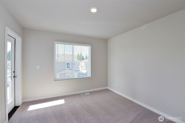 empty room with a healthy amount of sunlight, visible vents, carpet floors, and baseboards