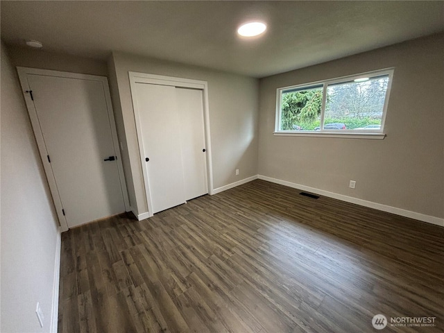 11713 100 Avenue Ct E, Puyallup, WA 98373 - unfurnished bedroom with visible vents, baseboards, a closet, and dark wood-style flooring