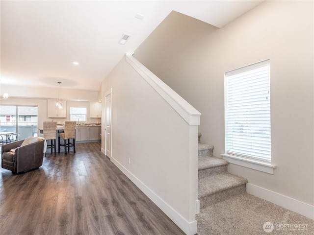 stairway featuring baseboards and wood finished floors