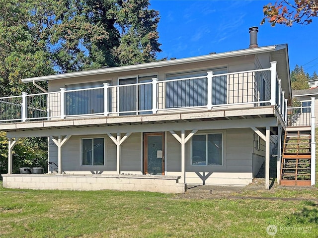 rear view of property with stairway and a yard