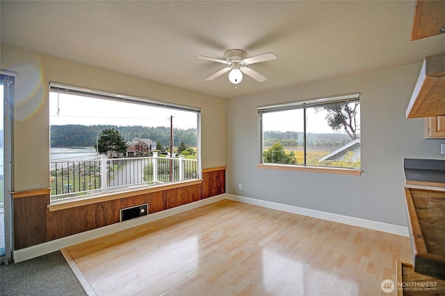 interior space featuring plenty of natural light, light wood-style flooring, and a ceiling fan