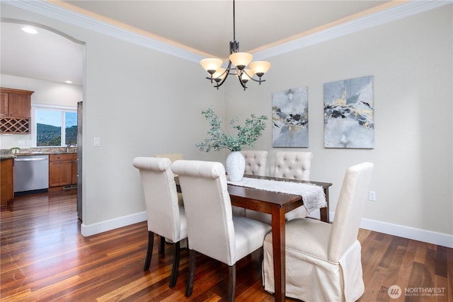 dining room featuring a notable chandelier, ornamental molding, baseboards, and dark wood-style flooring