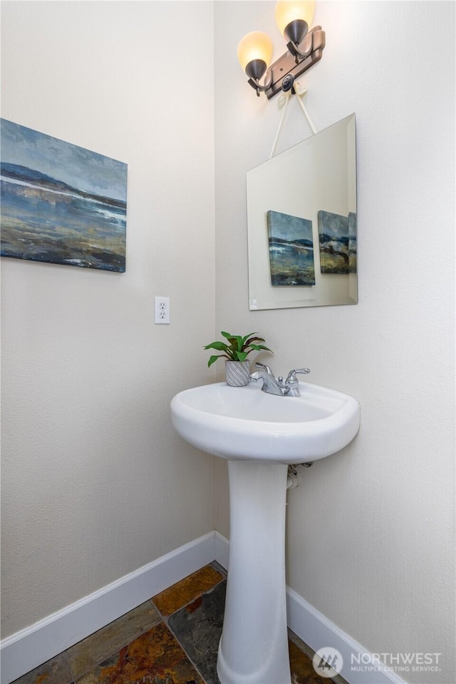 bathroom featuring baseboards and stone tile flooring