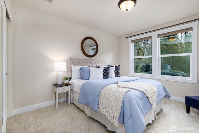 bedroom featuring baseboards and light carpet