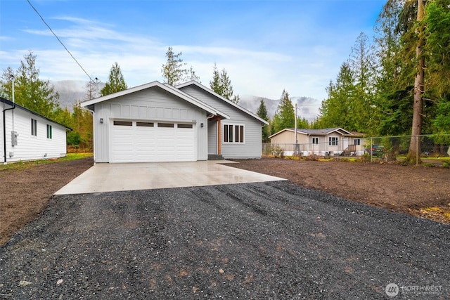 view of front of property with fence, board and batten siding, and driveway