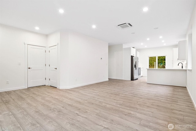 unfurnished living room with visible vents, recessed lighting, and light wood-style floors