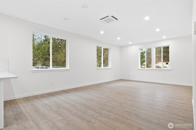 empty room featuring visible vents, recessed lighting, light wood-type flooring, and baseboards