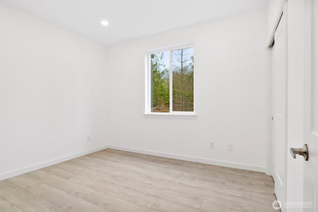 unfurnished room with recessed lighting, baseboards, and light wood-style floors