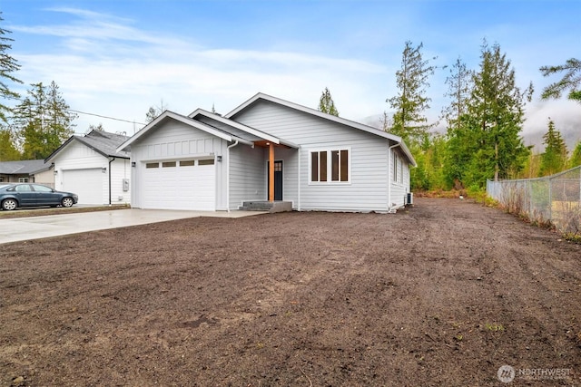 view of front of home featuring an attached garage, fence, and driveway