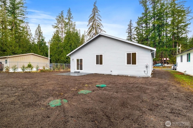 rear view of property featuring a patio and fence