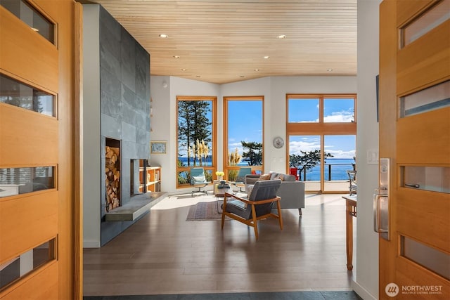 living room featuring wood finished floors, a high ceiling, recessed lighting, a tile fireplace, and wooden ceiling