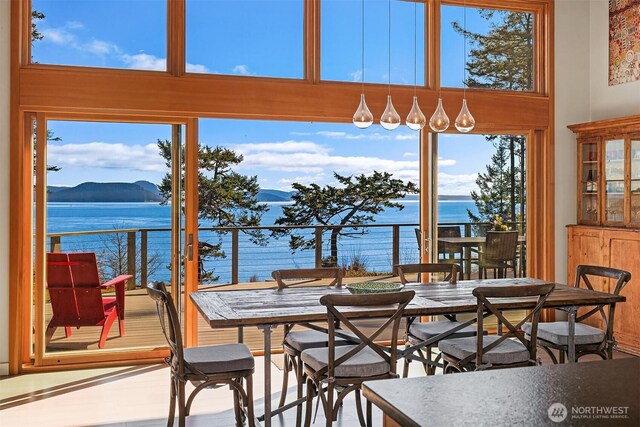dining room featuring a water view and a towering ceiling