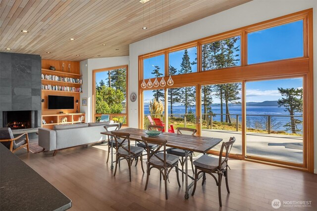 dining area featuring recessed lighting, wood finished floors, wooden ceiling, and a fireplace