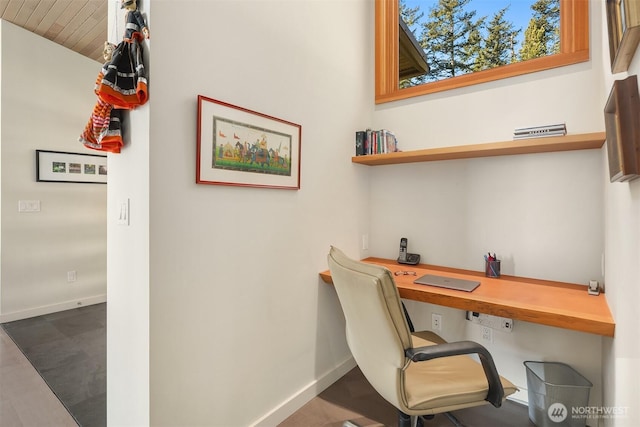 office space featuring baseboards, wood ceiling, and built in study area
