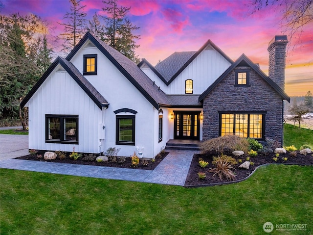 view of front of home featuring a front lawn, a chimney, and a shingled roof