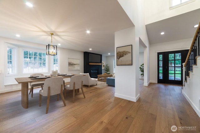 dining space with stairway, recessed lighting, light wood-type flooring, and baseboards