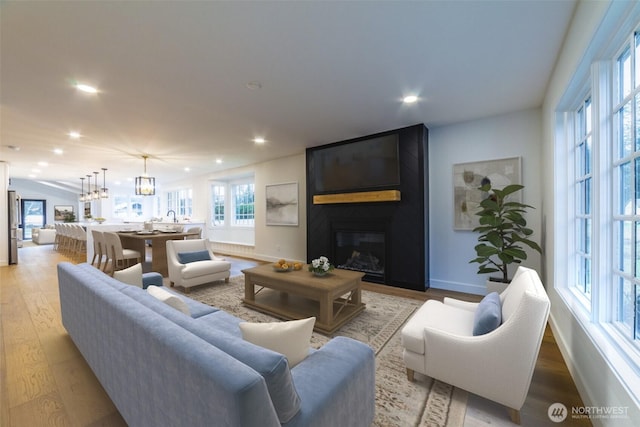 living room with recessed lighting, a fireplace, and light wood-type flooring