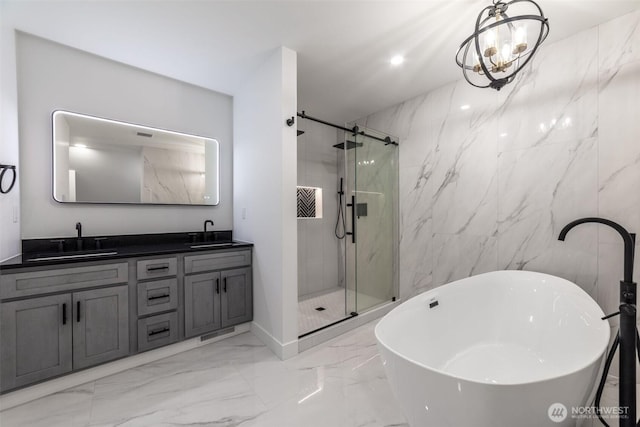 bathroom featuring marble finish floor, a stall shower, and a sink