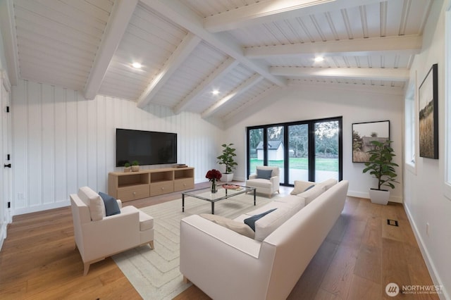 living area with lofted ceiling with beams, light wood-style floors, and baseboards