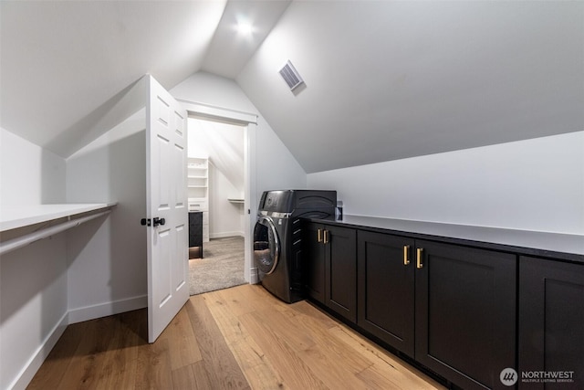 laundry room with visible vents, baseboards, washer / dryer, light wood-style floors, and cabinet space