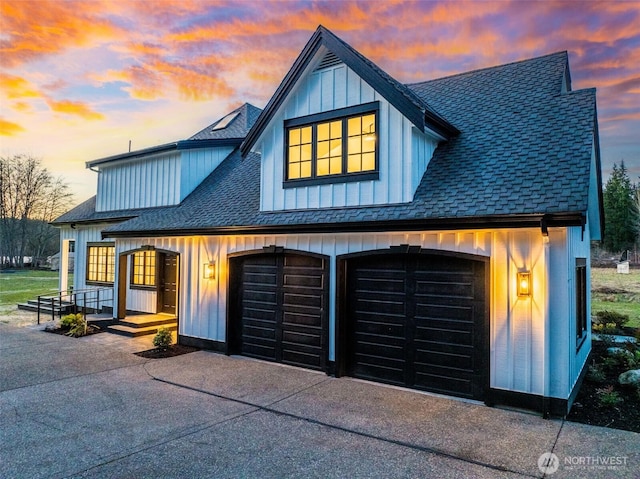 modern farmhouse style home featuring board and batten siding, an attached garage, driveway, and roof with shingles