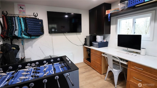 home office with light wood-style floors and built in desk