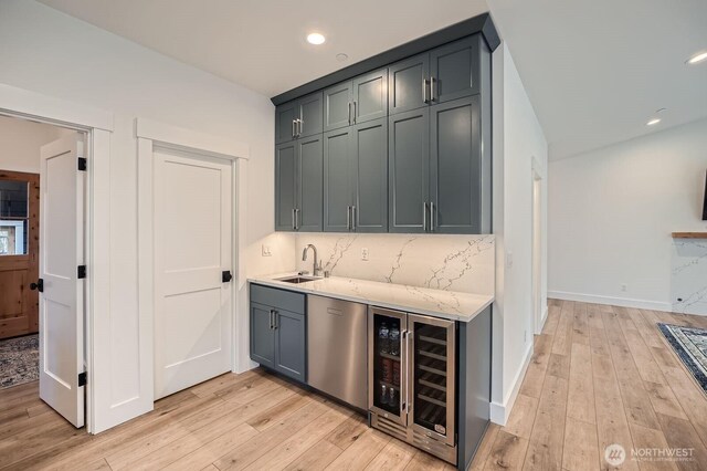 bar with a sink, recessed lighting, wine cooler, light wood finished floors, and decorative backsplash