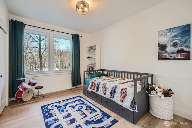 bedroom with hardwood / wood-style floors and baseboards