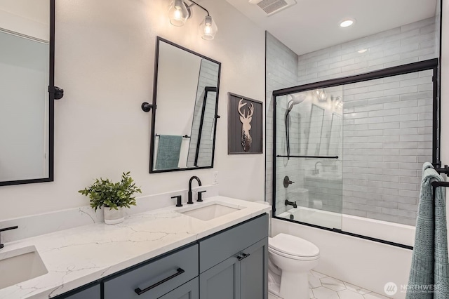 bathroom with double vanity, combined bath / shower with glass door, visible vents, and a sink