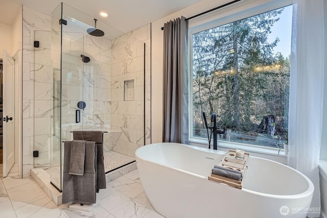 full bathroom featuring a freestanding bath, marble finish floor, and a shower stall