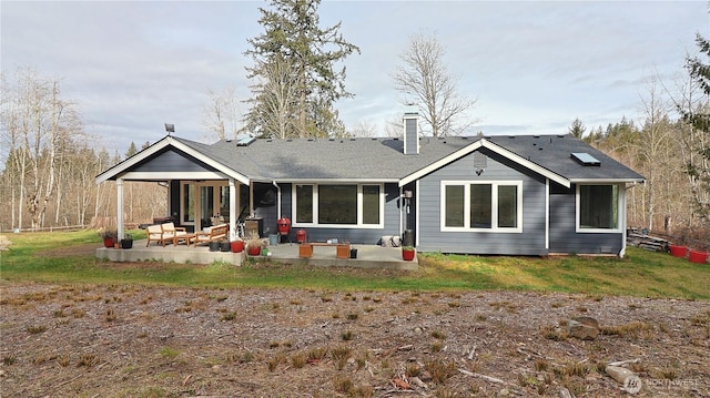 rear view of property featuring a patio and a chimney