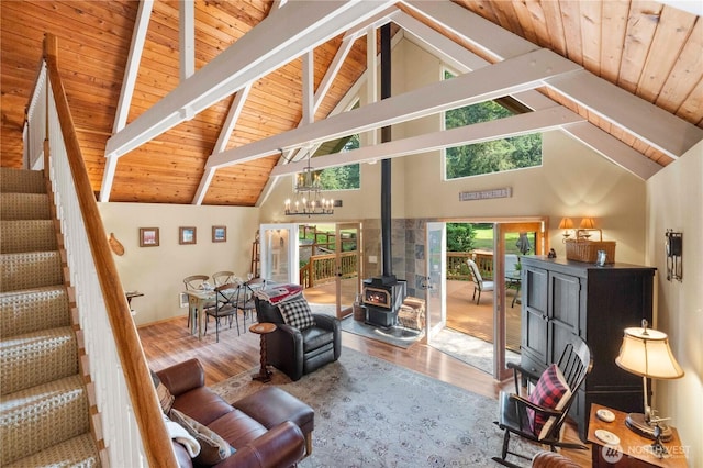 living room with stairway, wood ceiling, wood finished floors, and a wood stove