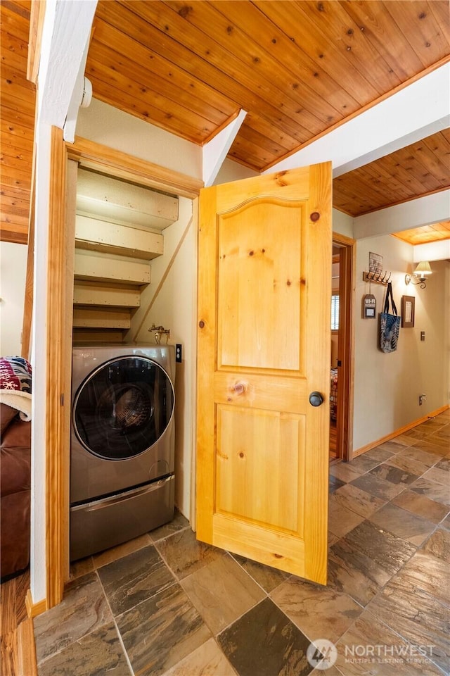 clothes washing area with washer / clothes dryer, stone tile floors, wooden ceiling, and laundry area