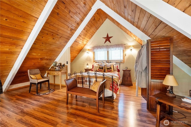 bedroom with lofted ceiling with beams, wood finished floors, and wooden ceiling