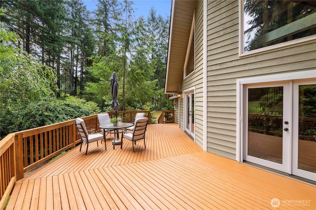 wooden deck with outdoor dining space and french doors