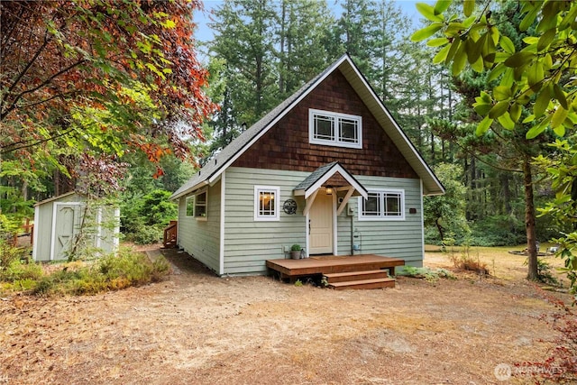 back of house with an outdoor structure and a storage unit