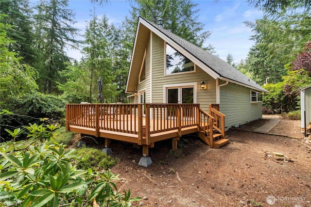 back of house with a deck and roof with shingles