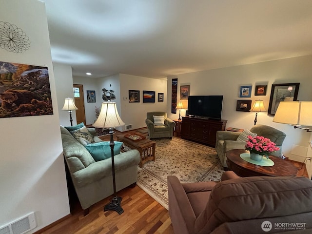 living area featuring wood finished floors and visible vents