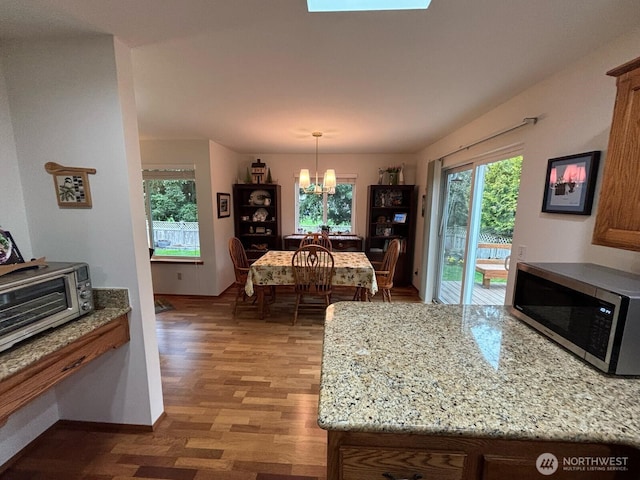 dining space featuring light wood-style floors, baseboards, and a chandelier