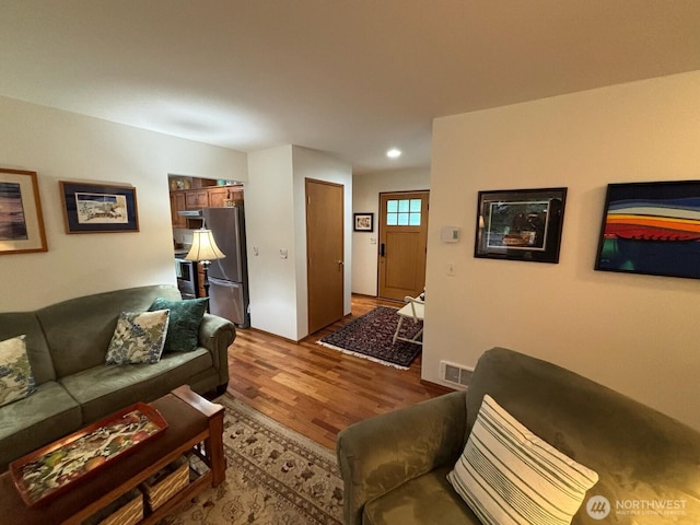 living room with visible vents and wood finished floors