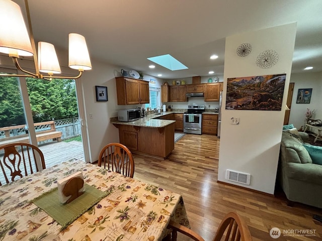 dining room with visible vents, baseboards, a skylight, light wood-style flooring, and recessed lighting