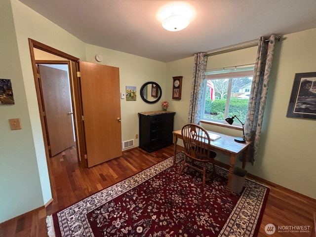 home office featuring visible vents, baseboards, and wood finished floors