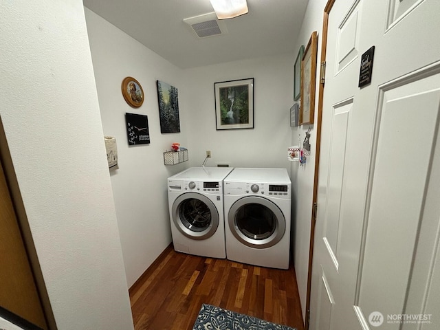 laundry area featuring visible vents, dark wood-style flooring, laundry area, and washing machine and clothes dryer