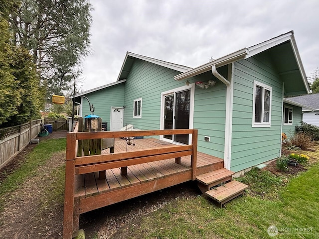 rear view of property featuring a deck and fence