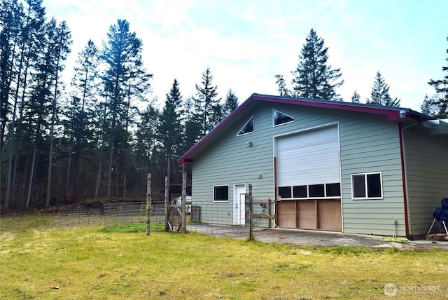 view of outdoor structure featuring a garage and fence