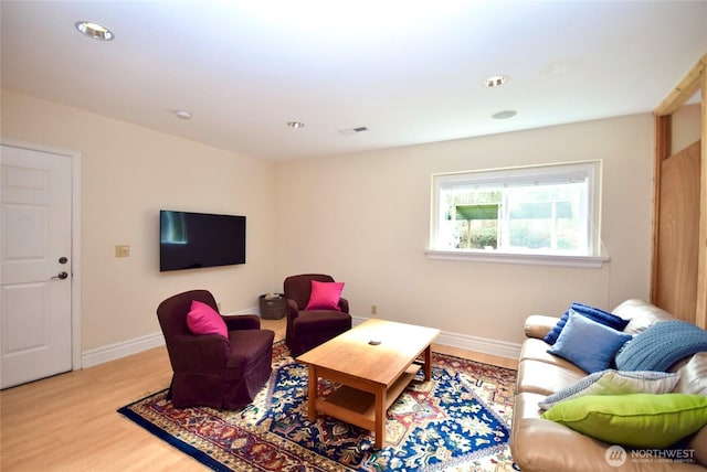 living area with recessed lighting, baseboards, and wood finished floors